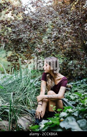 Giovane donna seduta in posizione di parcheggio Foto Stock