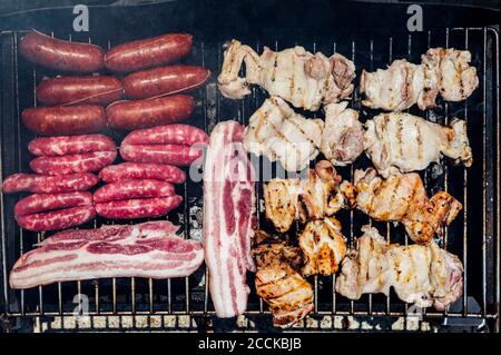 Primo piano di cottura della carne sul barbecue in cortile Foto Stock