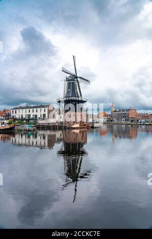 Paesi Bassi, Olanda settentrionale, Haarlem, canale fluviale Spaarne e mulino a vento De Adriaan Foto Stock