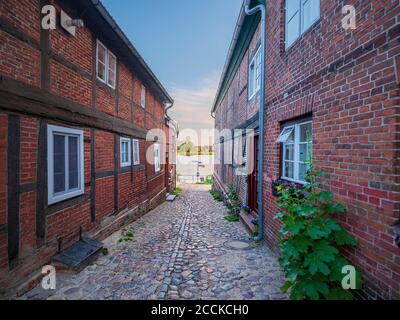 Germania, Schleswig-Holstein, Lauenburg, vicolo di Cobblestone tra case in mattoni Foto Stock