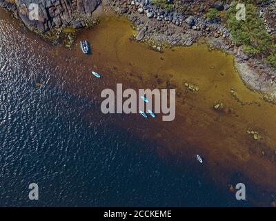 Russia, Oblast di Murmansk, distretto di Kolsky, Teriberka, surfisti SUP sul fiume Teriberka, vista aerea Foto Stock