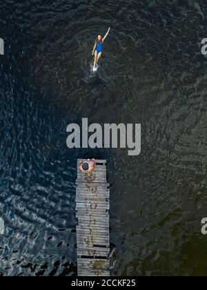 Vista aerea dell'uomo e della donna che nuotano nel lago Foto Stock