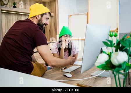 Buona coppia di lavoro che usa il computer alla scrivania in un ufficio moderno Foto Stock