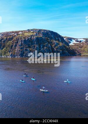 Russia, Oblast di Murmansk, distretto di Kolsky, Teriberka, surfisti SUP sul fiume Teriberka, vista aerea Foto Stock