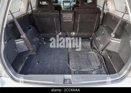 Vano bagagliaio aperto e spazioso di un portellone giapponese grigio con copertura in tessuto grigio dopo la pulizia a secco durante la preparazione in prevendita. Taxi cargo per tran Foto Stock