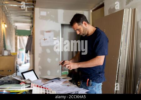 Uomo che prende smartphone immagine del piano di costruzione Foto Stock