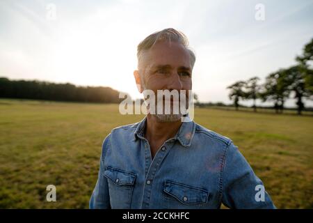 Contenuto uomo maturo su un prato in campagna Foto Stock