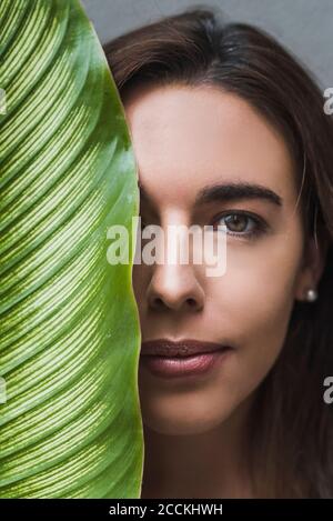 Primo piano ritratto di bella donna con foglia Foto Stock