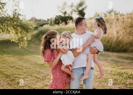 Felici genitori con due figlie su un prato Foto Stock