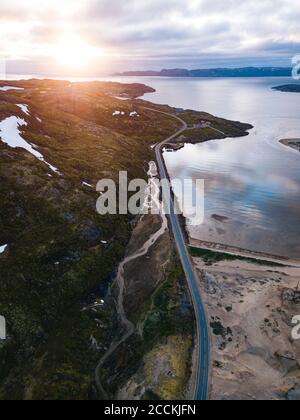 Russia, Oblast di Murmansk, Teriberka, veduta aerea della strada costiera al tramonto Foto Stock