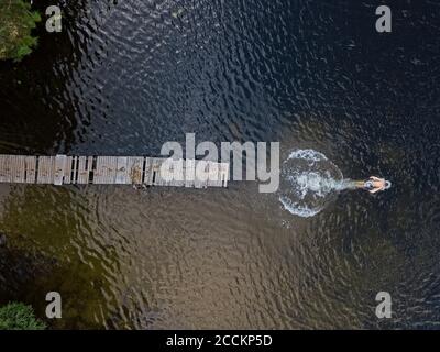 Vista aerea del giovane uomo che nuota nel lago Foto Stock