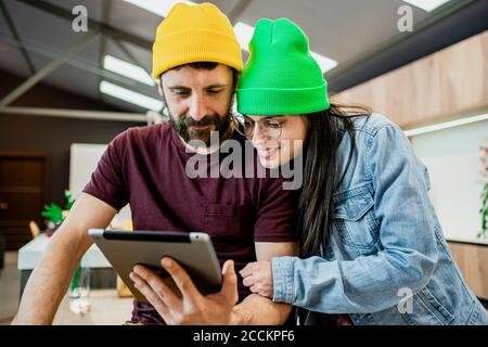 Una buona coppia di lavoro che utilizza un tablet digitale in un ufficio moderno Foto Stock