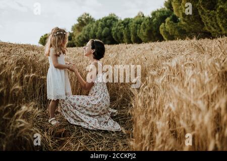 Madre e figlia che condividono buoni momenti in campo di grano Foto Stock