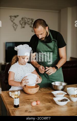 Padre e figlia che cuocitano i biscotti a casa Foto Stock