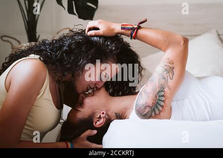 Primo piano di una coppia di donne che si baciano in camera da letto a casa Foto Stock