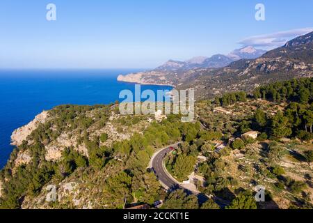 Spagna, Maiorca, Deia, Drone vista della strada costiera e paesaggio circostante di Serra de Tramuntana Foto Stock