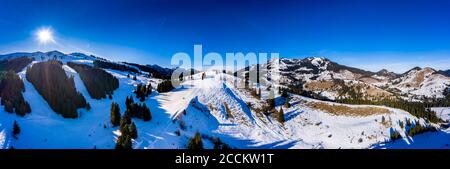 Panorama in elicottero del sole che splende sulle cime innevate di Mangfall Montagne Foto Stock