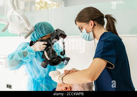 Medico femminile e infermiera con paziente in clinica dentista Foto Stock