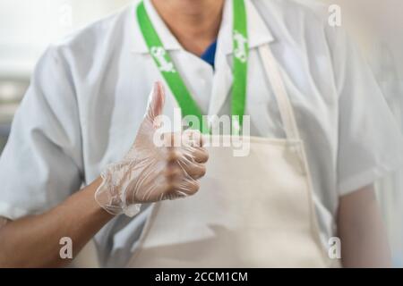 Closeup di un giovane medico ispanico mostrando pollici in su Foto Stock