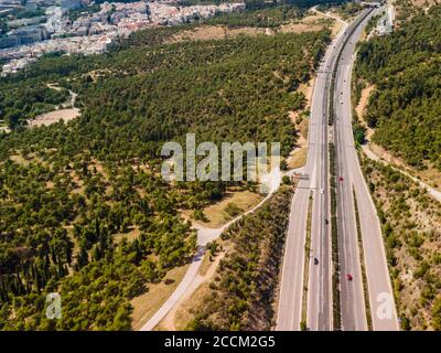 Thessaloniki, Grecia paesaggio di droni aerei di traffico sulla circonvallazione interna di Periferiaki. Panorama di un giorno sull'autostrada europea con auto che attraversano la foresta. Foto Stock