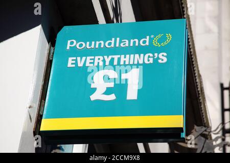 Cardiff, Galles, Regno Unito , 31 agosto 2016 : segno pubblicitario del logo Poundland fuori dal suo negozio di commercio al dettaglio in immagine di foto di stock di Queen Street Foto Stock