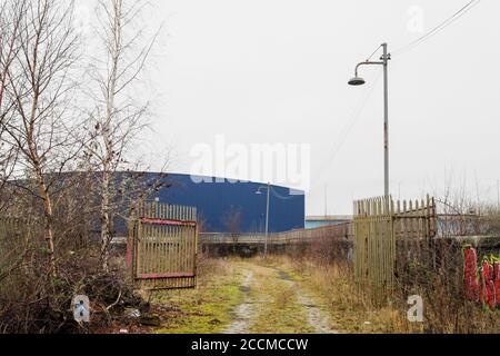 Strada acciottolata o strada sopravvolta e luci di strada in disuso, fuori Maxwell Road, Glasgow. Estensione M74 visibile in background. 2017. Foto Stock