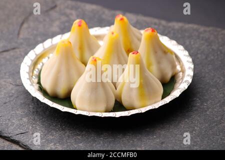 Modak al vapore, a base di farina di riso e ripieno di gelatiere al cocco. Modak è un dolce indiano tradizionale fatto durante Ganesh Utsav e offerto anche a lord Foto Stock