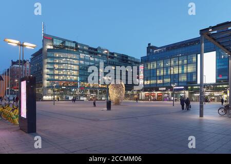 Vista notturna su piazza Narinkka a Kamppi, Helsinki, Finlandia, con il monumento agli imprenditori progettato dall'artista Eva Löfdahl nel centro Foto Stock