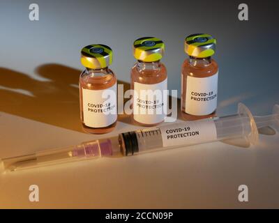 Flaconcini di vaccino contro covid-19 con ago per iniezione e protezione etichetta contro il coronavirus sul tavolo Foto Stock
