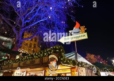 Atmosfera notturna e concentrazione selettiva al cartello di Babbo Natale illuminano le bancarelle di Heumarkt, famosa piazza del mercato di Natale a Köln, Germania. Foto Stock