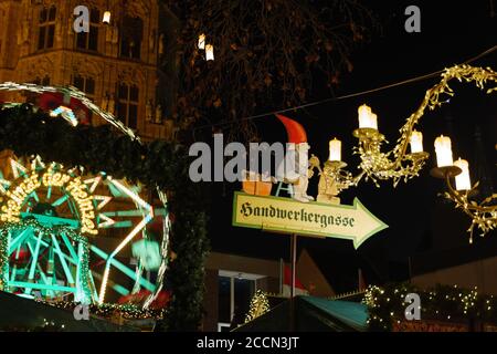 Atmosfera notturna e concentrazione selettiva al cartello di Babbo Natale illuminano le bancarelle di Heumarkt, famosa piazza del mercato di Natale a Köln, Germania. Foto Stock