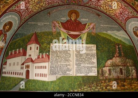 Monastero di Sâmbăta de Sus, Contea di Brasov, Romania. Targa informativa e grande affresco raffigurante la Vergine Maria, protettrice della chiesa. Foto Stock