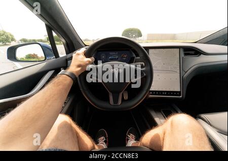 Persona che guida un nuovo SUV Tesla. L'interno di un SUV Tesla Model X, completamente elettrico, di lusso, a croce, di dimensioni standard Foto Stock