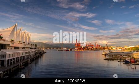 Tramonto sul Vancouver Container Port e il Porto tra il Terminal delle navi da crociera Canada Place e Waterfront Skytrain e Seabus Terminale Foto Stock