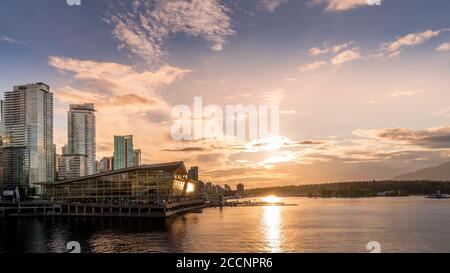 Tramonto sul Terminal degli idrovolanti e sull'alto Condominio Torri nel quartiere di Coal Harbour sulla riva di Porto di Vancouver Foto Stock