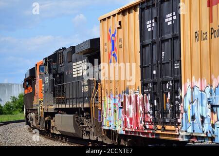 Mendota, Illinois, Stati Uniti. Tre locomotive, tra cui e off-Road Power Norfolk Southern unità guidare un Burlington Northern Santa Fe treno misto merci. Foto Stock