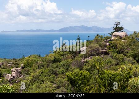 Viste dell'oceano dal sentiero dei forti, fitta vegetazione, montagne all'orizzonte, Magnetic Island, Queensland, Australia Foto Stock