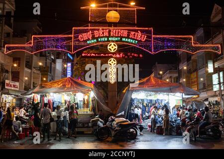 Mercato notturno in Asia. Persone a piedi o in moto. Comprare vestiti e cibo. Nessuna distanza sociale prima di Covid-19. Ninh Kieu mercato, Can Tho, Vietnam Foto Stock