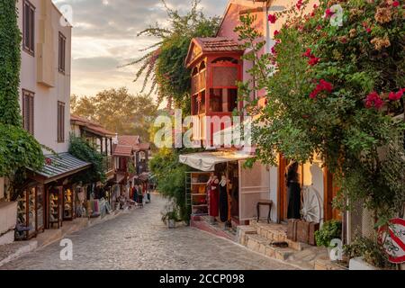 Bella strada nel centro storico di Kas con boutique al tramonto, Turchia Foto Stock