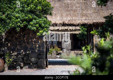 Scenario della statua di Dol Hareubang all'interno del Villaggio Folcloristico di Seongeup nell'isola di Jeju, Corea del Sud. Foto Stock