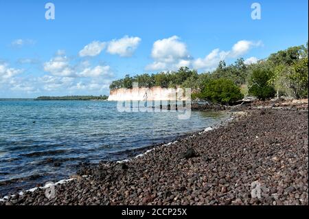 Spiaggia di ciottoli e scogliera colorata presso lo storico insediamento Victoria, la Penisola di Cobourg, Arnhem Land, Northern Territory, NT, Australia Foto Stock