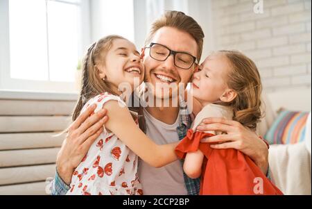 Famiglia felice amorevole. Daddy e le sue figlie ragazze bambini che giocano insieme. Concetto del giorno del Padre. Foto Stock