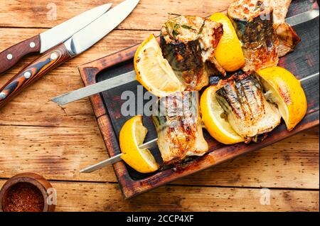 Spiedini grigliati di sgombro.Pesce spiedino barbecue su vecchio tavolo di legno Foto Stock