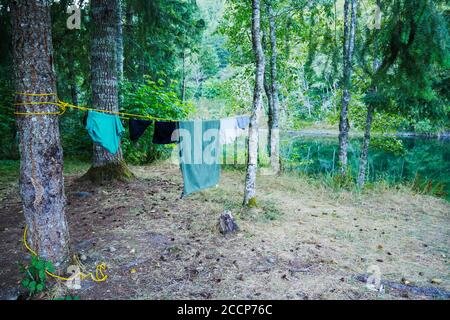 Vestiti che asciugano su una linea in un campeggio da un fiume Foto Stock