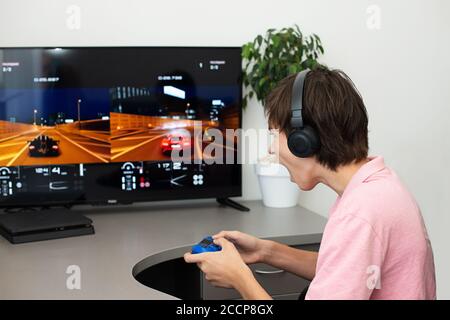 Orenburg, Russia, 19, giugno 2020. Sony PlayStation 4. Gran truismo sport. Teenager gioca un gioco per computer con cuffie e un joystick, console di gioco. Foto Stock