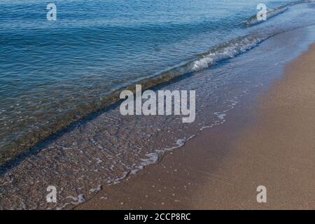 onde di mare su una spiaggia sabbiosa nel pomeriggio Foto Stock