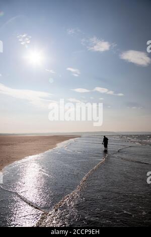 Donna che si addormentava a Llanddona Beach, Anglesey, Galles del Nord Foto Stock