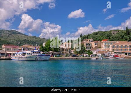 Isola di Corfù/Grecia - 6 maggio 2019: Vista sul bellissimo villaggio di Kassiopi – laguna di mare con acque turchesi calme, barche da crociera, case colorate e la strada Foto Stock