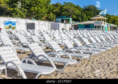 Spiaggia sedie di plastica sulla spiaggia vicino al mare in ora legale Foto Stock