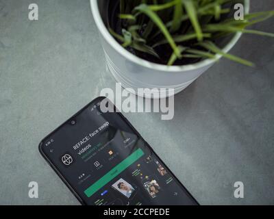 LOD, Israele - 8 luglio 2020: Moderno spazio di lavoro minimalista per ufficio con smartphone nero mobile con applicazione di reface play pagina del negozio su sfondo in marmo. Cl Foto Stock